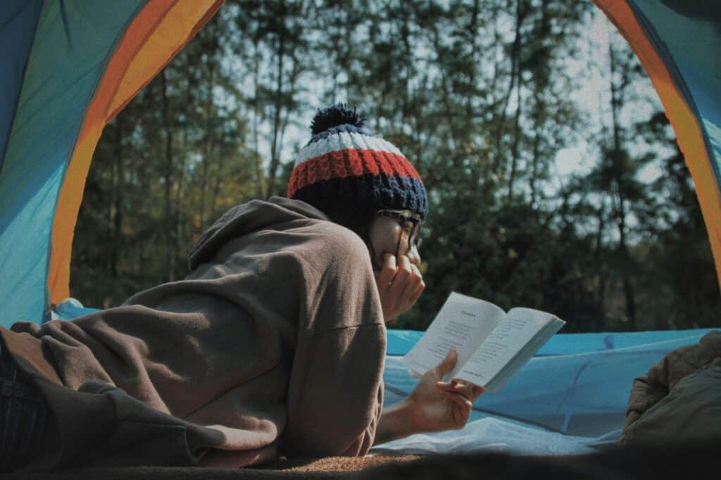 A tranquil scene set in a misty forest, where a reader is peacefully immersed in a book. This image gracefully captures the stress-relieving qualities of reading, as the individual escapes into a world of words and imagination. 